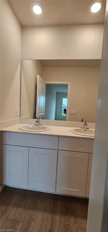 Dual vanity with white cabinetry, light-toned countertop, and undermount sinks