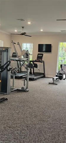 Fitness center with carpet flooring, mounted television, ceiling fan, and recessed lighting