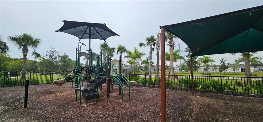 Playground structure with multiple slides and a shade canopy