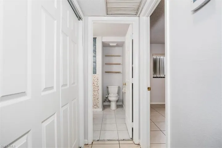 Hall featuring light tile patterned floors and a textured ceiling