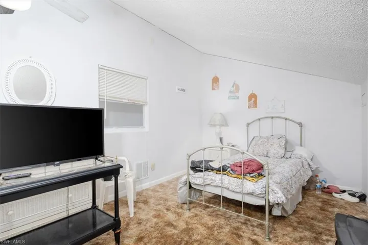 Bedroom featuring carpet flooring, a textured ceiling, and a ceiling fan