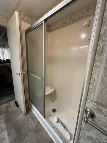 Full bathroom featuring a stall shower and dark flooring