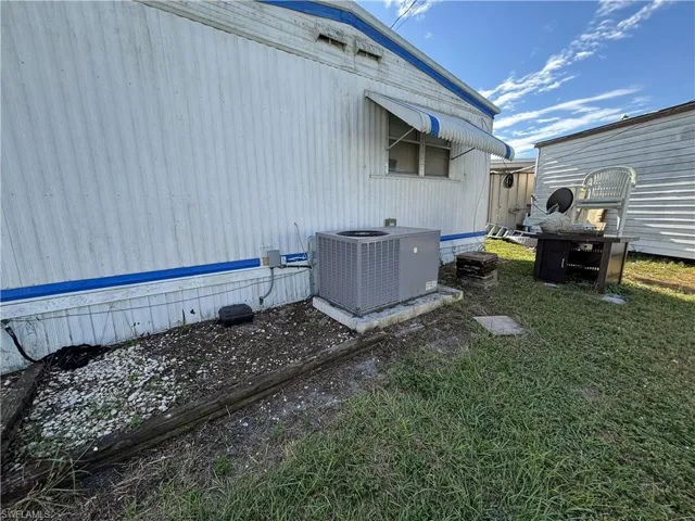 View of home's exterior featuring a cooling unit and a lawn