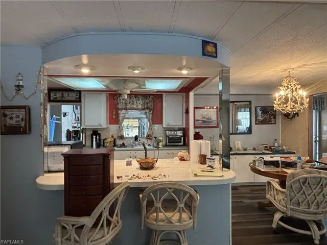 Kitchen, white cabinetry & and island with breakfast bar.