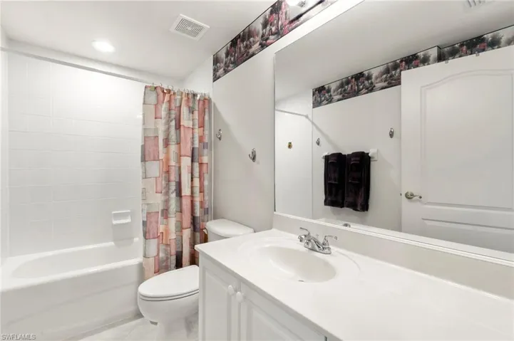 Full bathroom with toilet, shower / bathtub combination with curtain, vanity, tile patterned floors, and recessed lighting