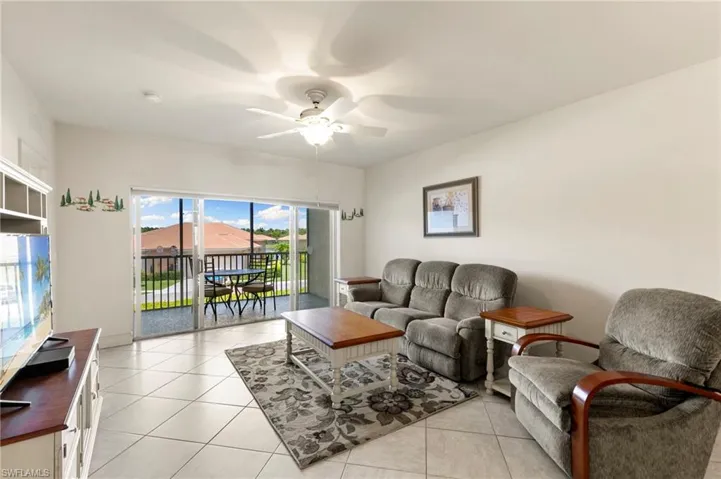 Living room featuring a ceiling fan and light tile patterned floors