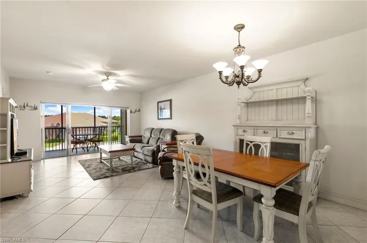 Dining area with a chandelier, a ceiling fan, and light tile patterned flooring