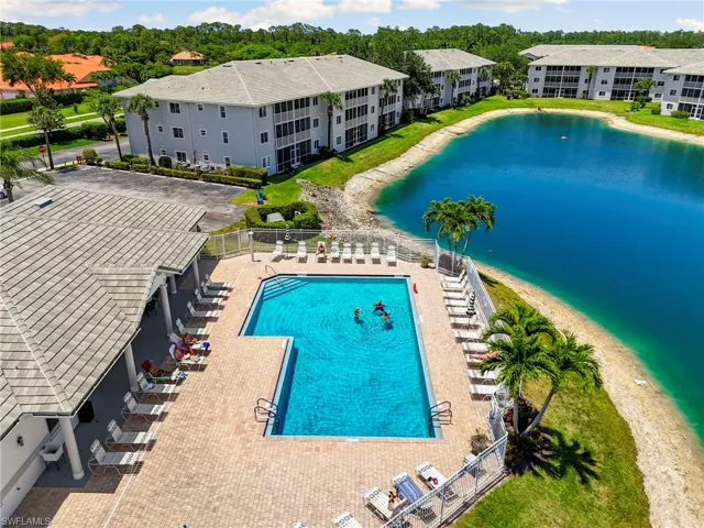 Community pool featuring a water view and fence