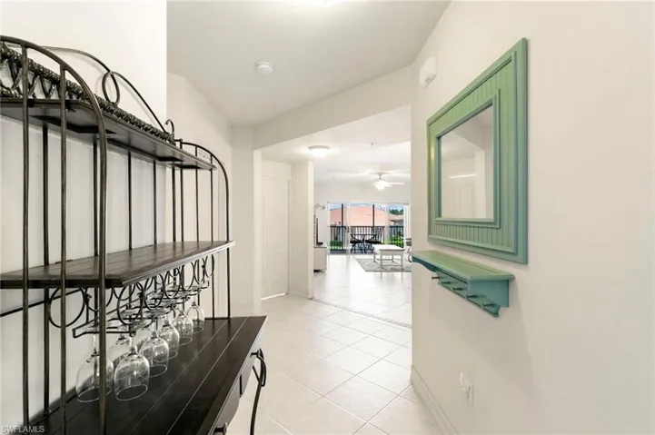 Hall featuring light tile patterned flooring and baseboards