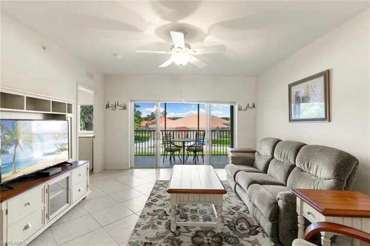 Living room featuring light tile patterned flooring and a ceiling fan