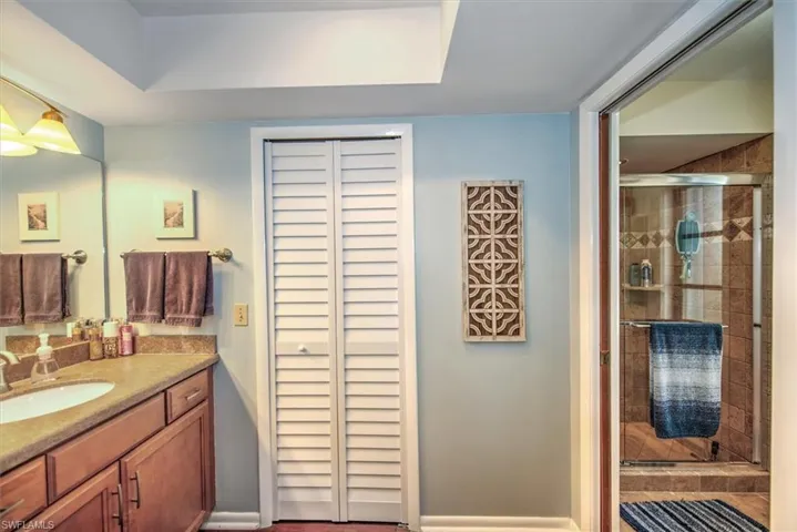 Bathroom featuring a shower with door and vanity