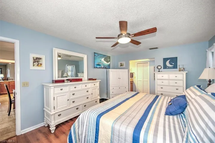 Bedroom featuring a textured ceiling, ceiling fan, a closet, and dark hardwood / wood-style floors