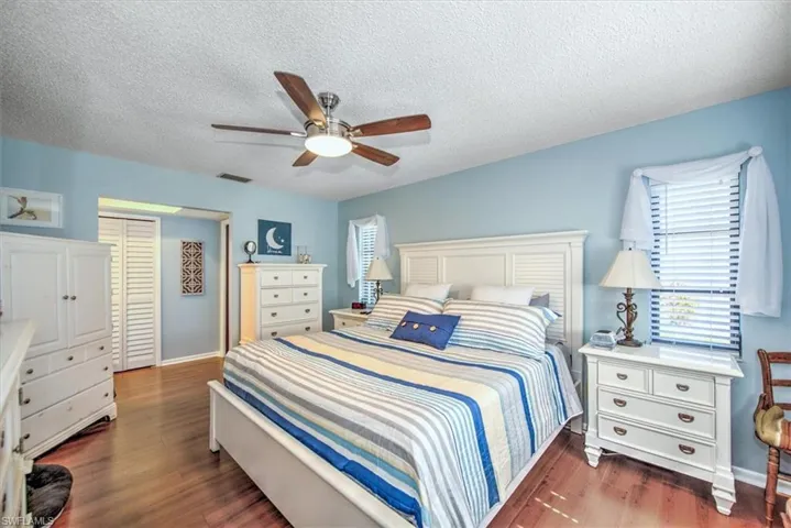 Bedroom featuring a textured ceiling, dark hardwood / wood-style flooring, and ceiling fan