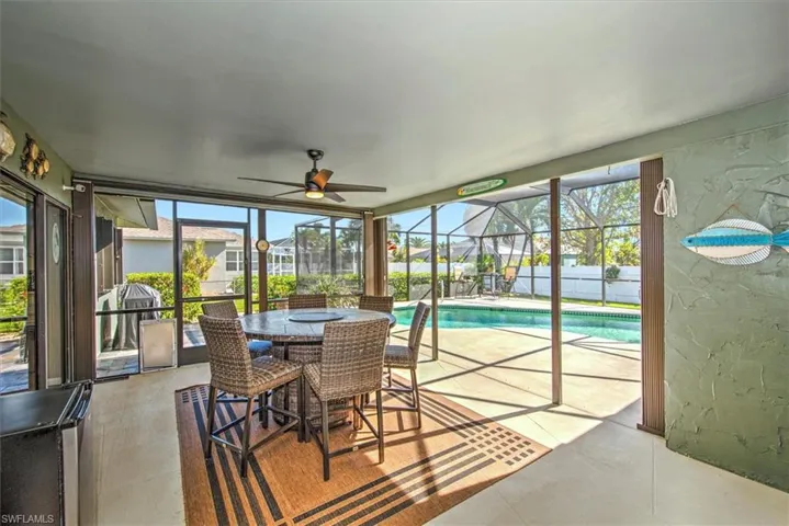 Sunroom / solarium featuring ceiling fan, a healthy amount of sunlight, and a pool