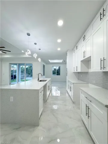 Kitchen with a sink, recessed lighting, and marble finish floor