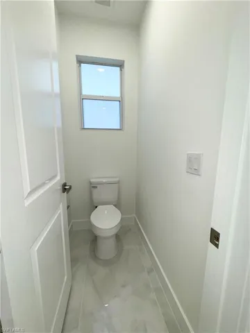 Bathroom with baseboards, toilet, and visible vents