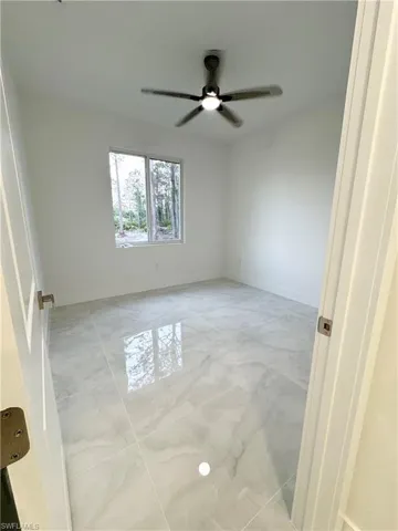 Spare room featuring ceiling fan, baseboards, and marble finish floor