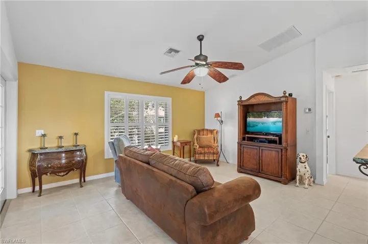 Living room with light tile patterned floors and ceiling fan