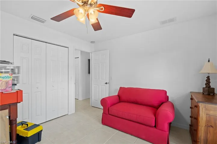 Living area featuring ceiling fan and light tile patterned floors