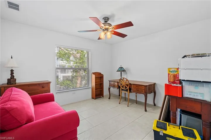 Living area with ceiling fan and light tile patterned floors