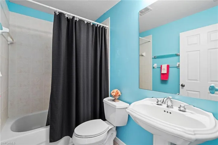 Full bathroom featuring shower / tub combo, toilet, and sink