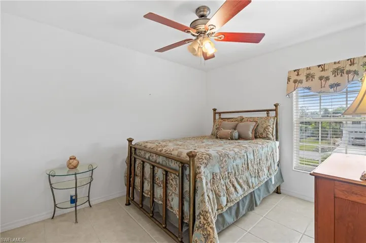 Tiled bedroom featuring ceiling fan