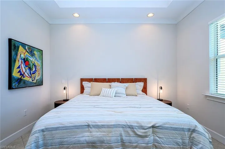 Bedroom featuring a skylight, light tile patterned floors, and ornamental molding