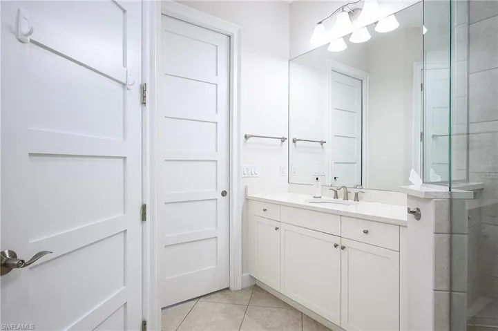 Bathroom with vanity, an enclosed shower, and tile patterned floors