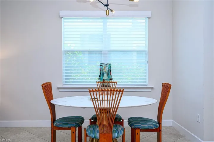 Tiled dining room featuring a healthy amount of sunlight