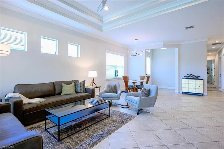 Living room featuring light tile patterned floors and crown molding