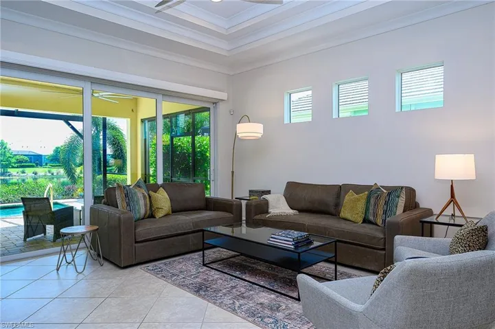 Living room featuring plenty of natural light, ceiling fan, ornamental molding, and light tile patterned floors