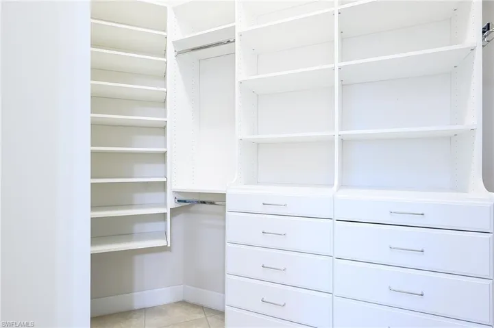 Walk in closet with light tile patterned floors