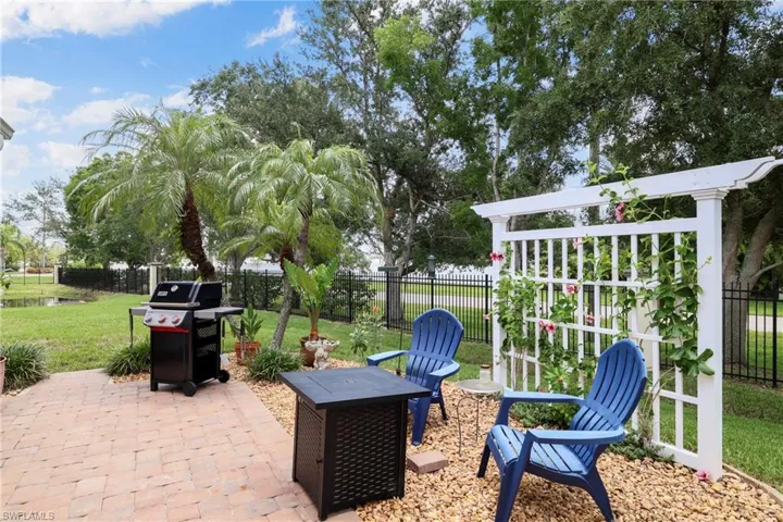 Paver patio with a white trellis feature, surrounded by gravel landscaping