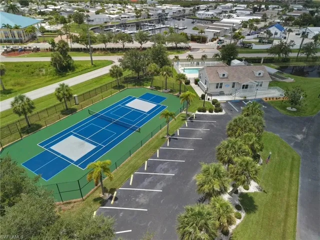 Fenced tennis court and pickleball courts with adjacent parking area