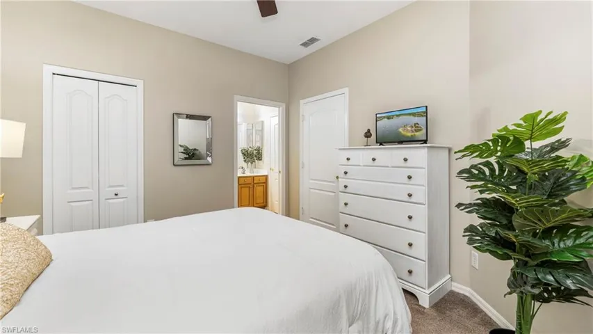 Bedroom featuring carpet floors, a ceiling fan, a closet, and connected bathroom