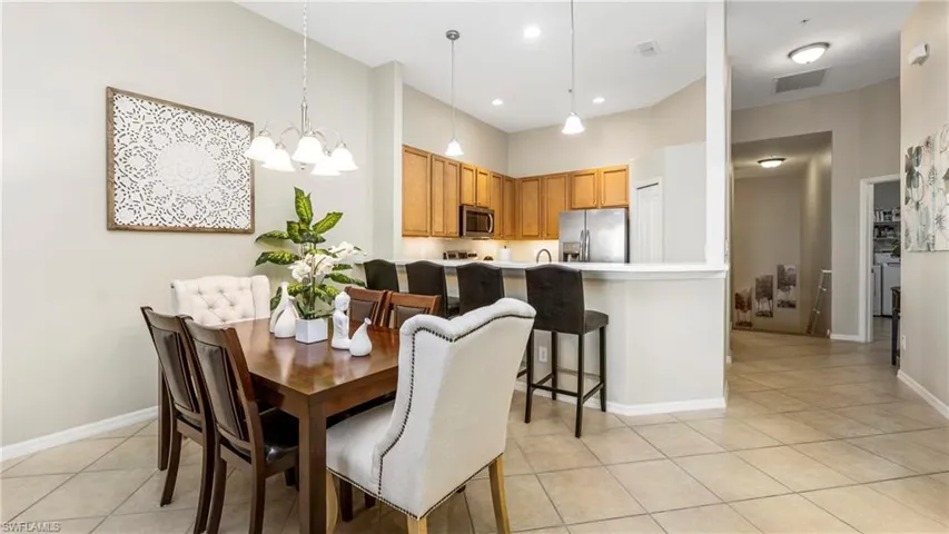 Dining room with a high ceiling, a chandelier, and light tile patterned floors