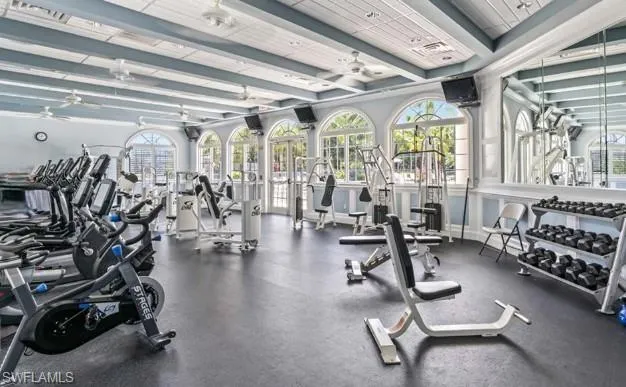 Exercise room with a ceiling fan and beamed ceiling
