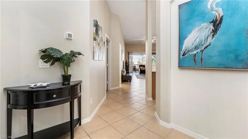 Corridor featuring baseboards and light tile patterned flooring