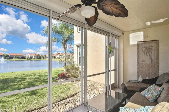 Sunroom / solarium featuring a water view and a ceiling fan