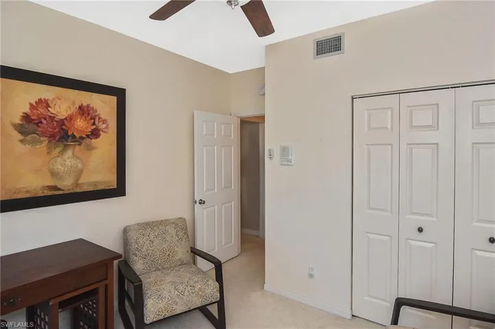 Sitting room with a ceiling fan, light colored carpet, visible vents, and baseboards