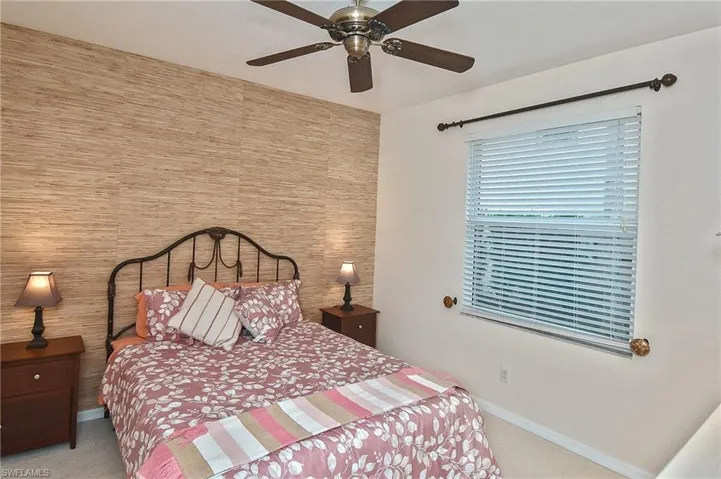 Bedroom featuring baseboards, ceiling fan, and light carpet