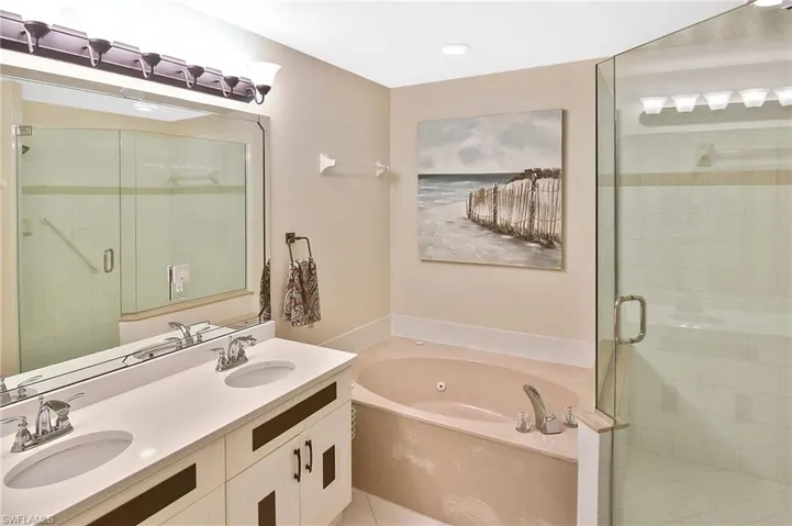 Full bath with a sink, a garden tub, and a stall shower