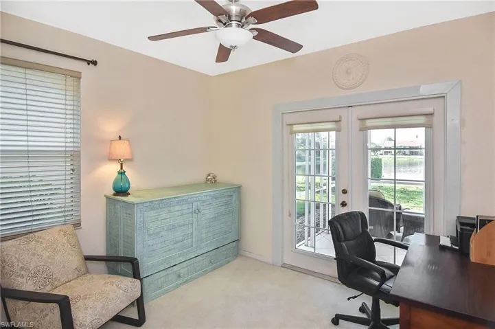 Carpeted home office featuring ceiling fan and french doors