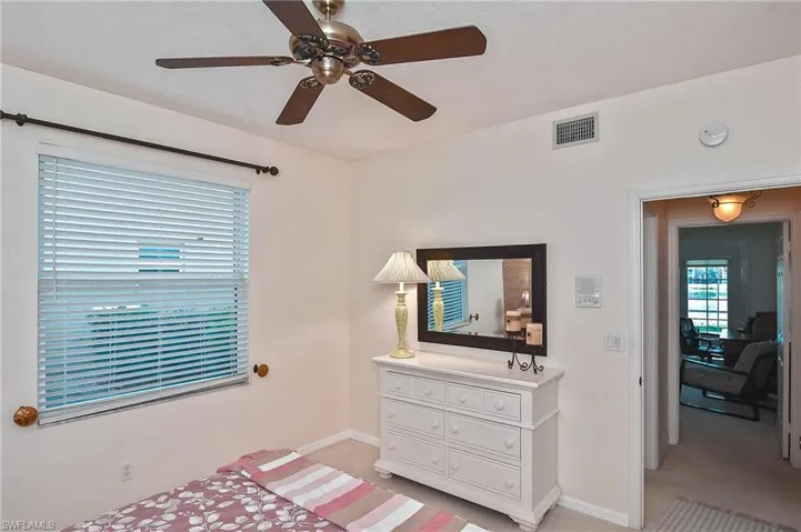 Bedroom featuring visible vents, a ceiling fan, baseboards, and light colored carpet