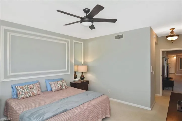 Carpeted bedroom with visible vents, a ceiling fan, and baseboards