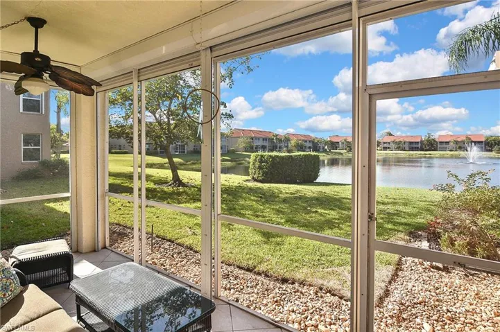 Sunroom featuring a water view, a residential view, and a ceiling fan