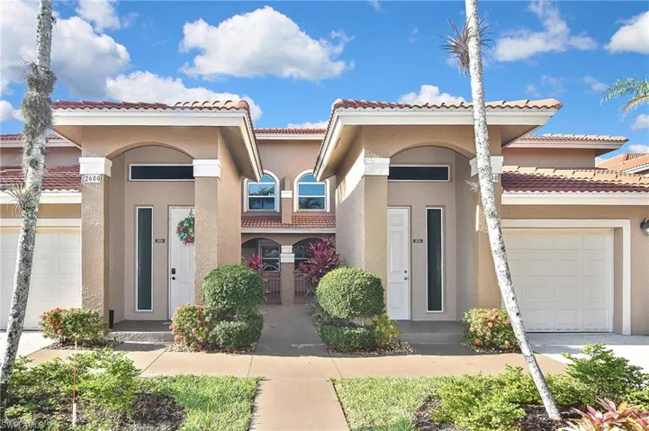 View of front of house featuring concrete driveway, an attached garage, a tile roof, and stucco siding
