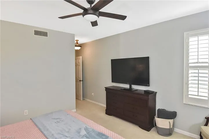 Bedroom featuring carpet floors, ceiling fan, baseboards, and visible vents