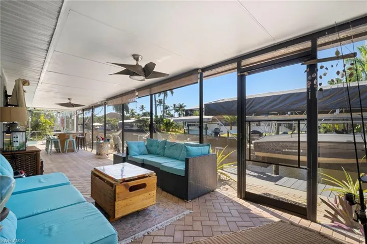 Sunroom / solarium with ceiling fan, a patio, and an outdoor lounge area with bar