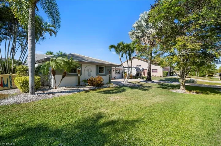 Ranch-style house featuring stucco siding, a front yard, and a tiled roof